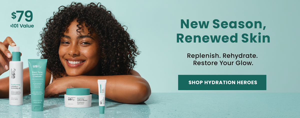 Woman smiling with an assortment of USRx skincare products on a light blue background with promotional text 'Shop Hydration Heroes'