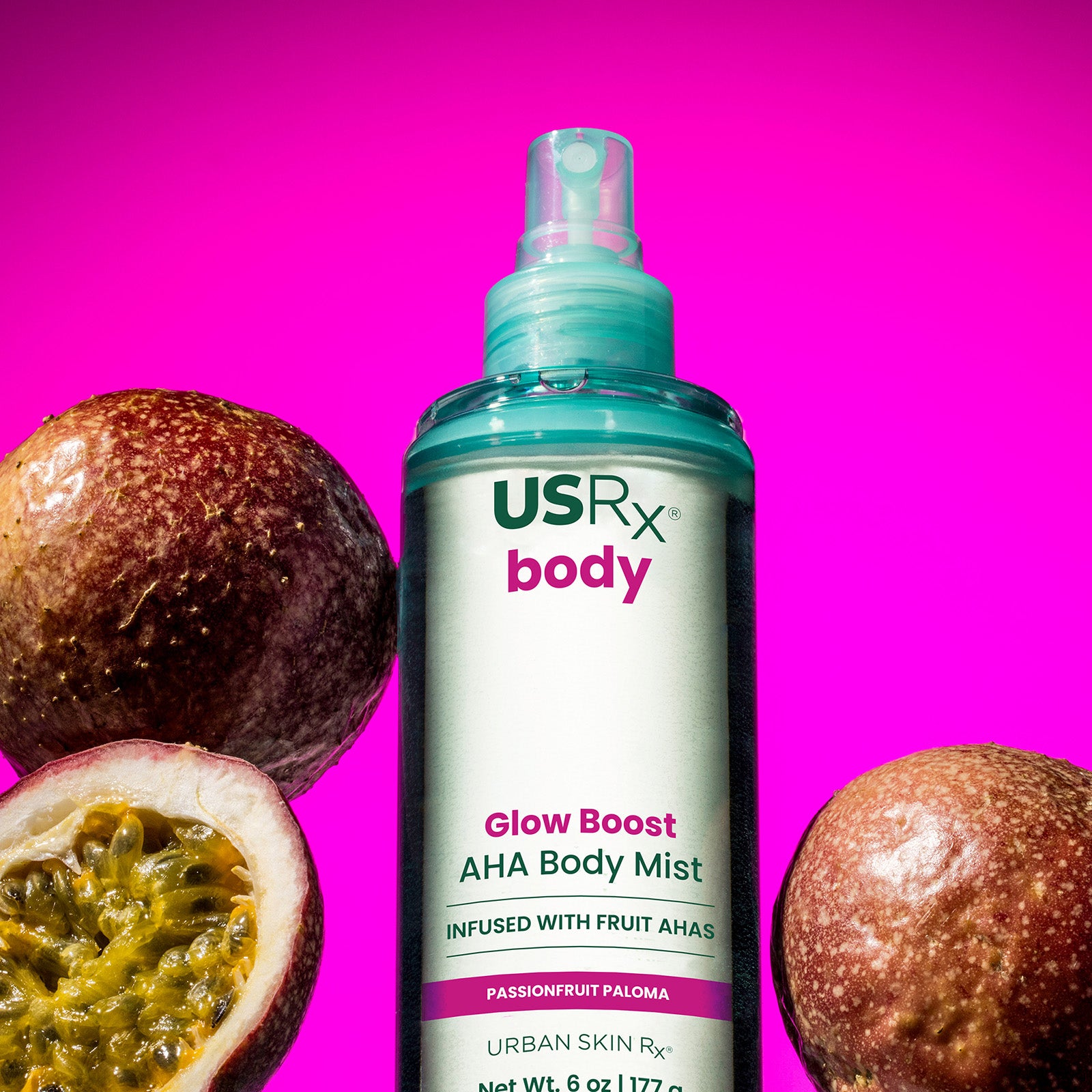 Bottle of USRx Glow Boost AHA Body Mist in Passionfruit Paloma surrounded by fresh passionfruit