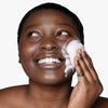 Woman applying USRx clear skin cleansing bar suds to her face