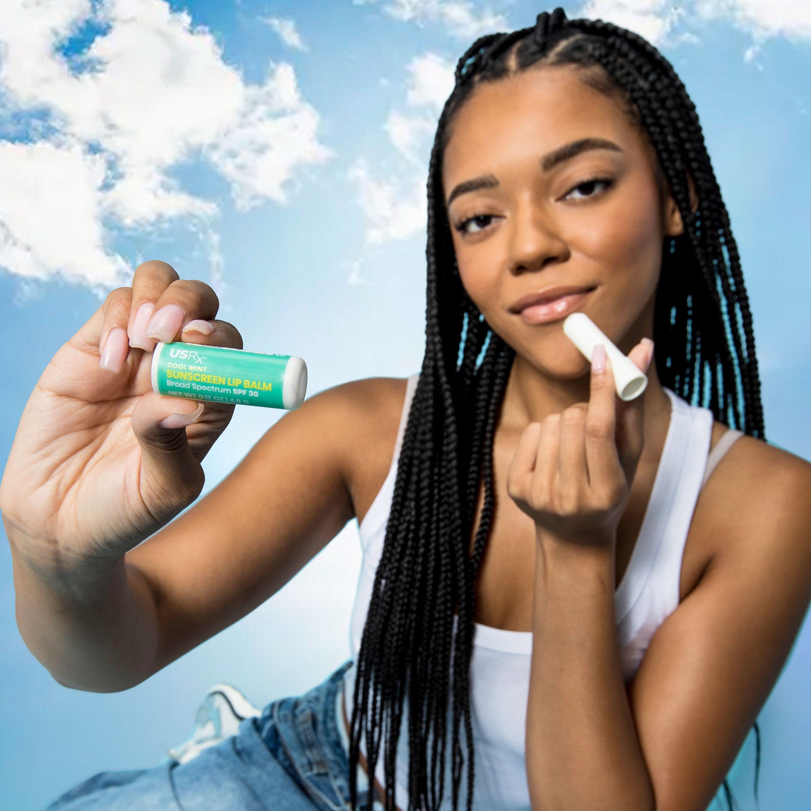 Woman holding a stick of Urban Skin RX Cool Mint Sunscreen Lip Balm up to her lips