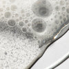 Close up of sudsy bubbles showing texture of Urban Skin Rx LacticGlow Micropolish Cleanser