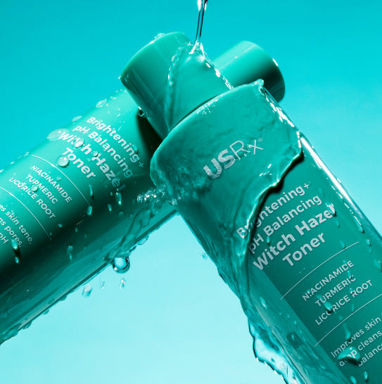 USRX Brightening Witch Hazel Toner bottle with water droplets on a blue background