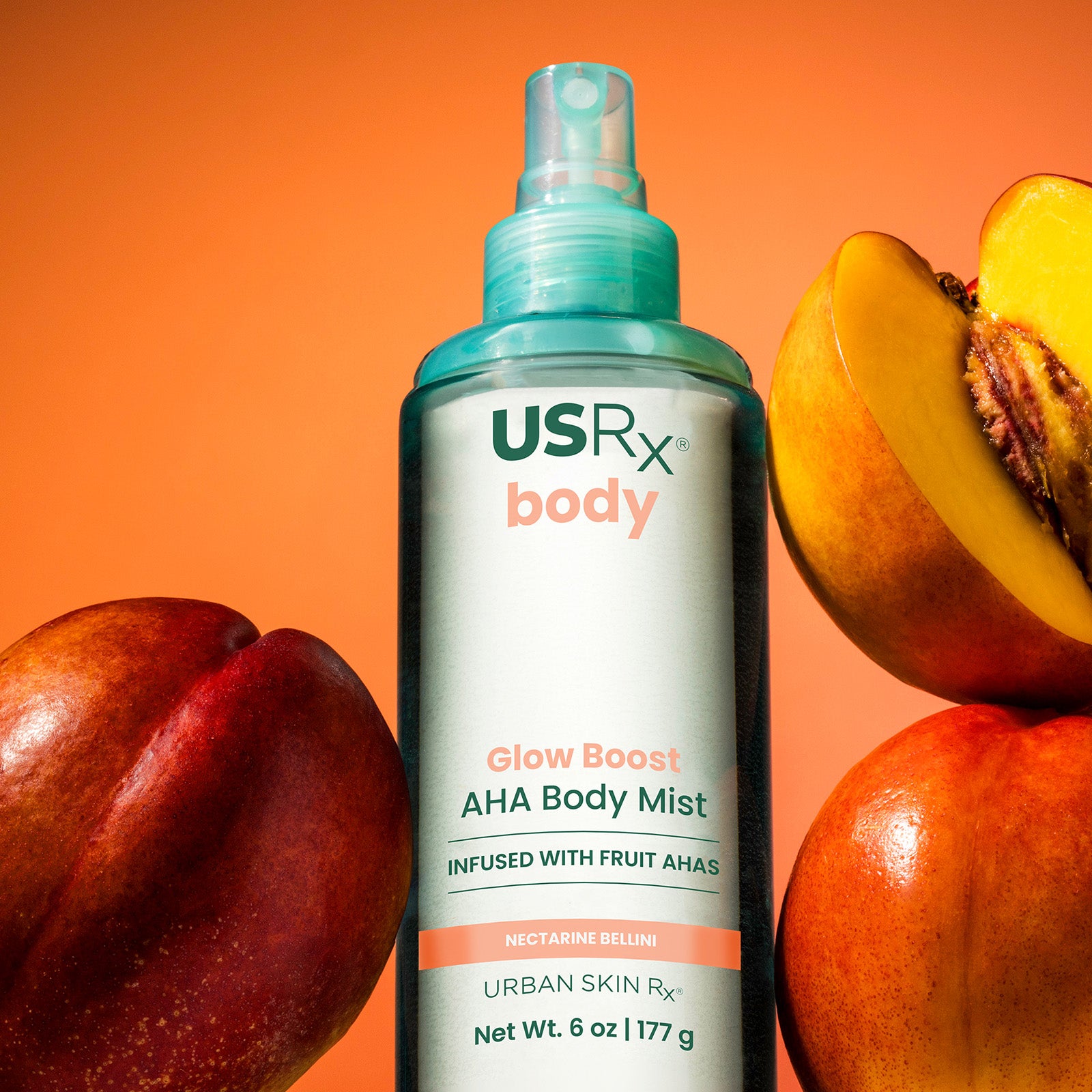Bottle of USRx Glow Boost AHA Body Mist in Nectarine Bellini surrounded by fresh nectarines