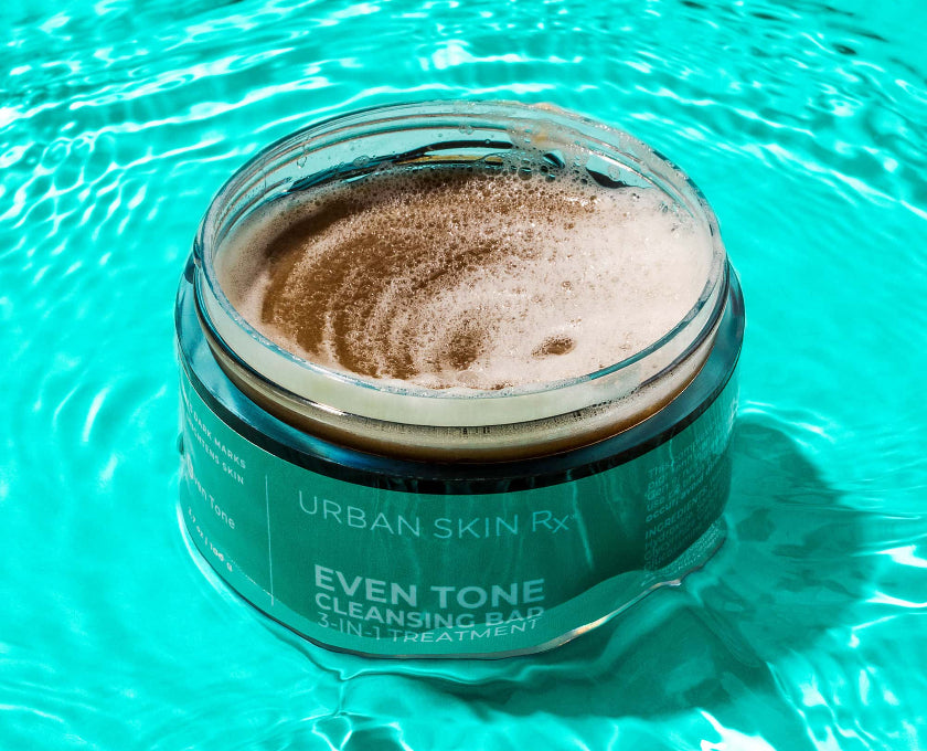 Jar of Urban Skin Rx Even Tone Cleansing Bar in blue water background