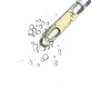 Close up of serum dispensing from a dropper on a white background