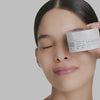 Diverse model holding Clear & EvenTone Clarifying Glycolic Pads which remove excess oil near her face