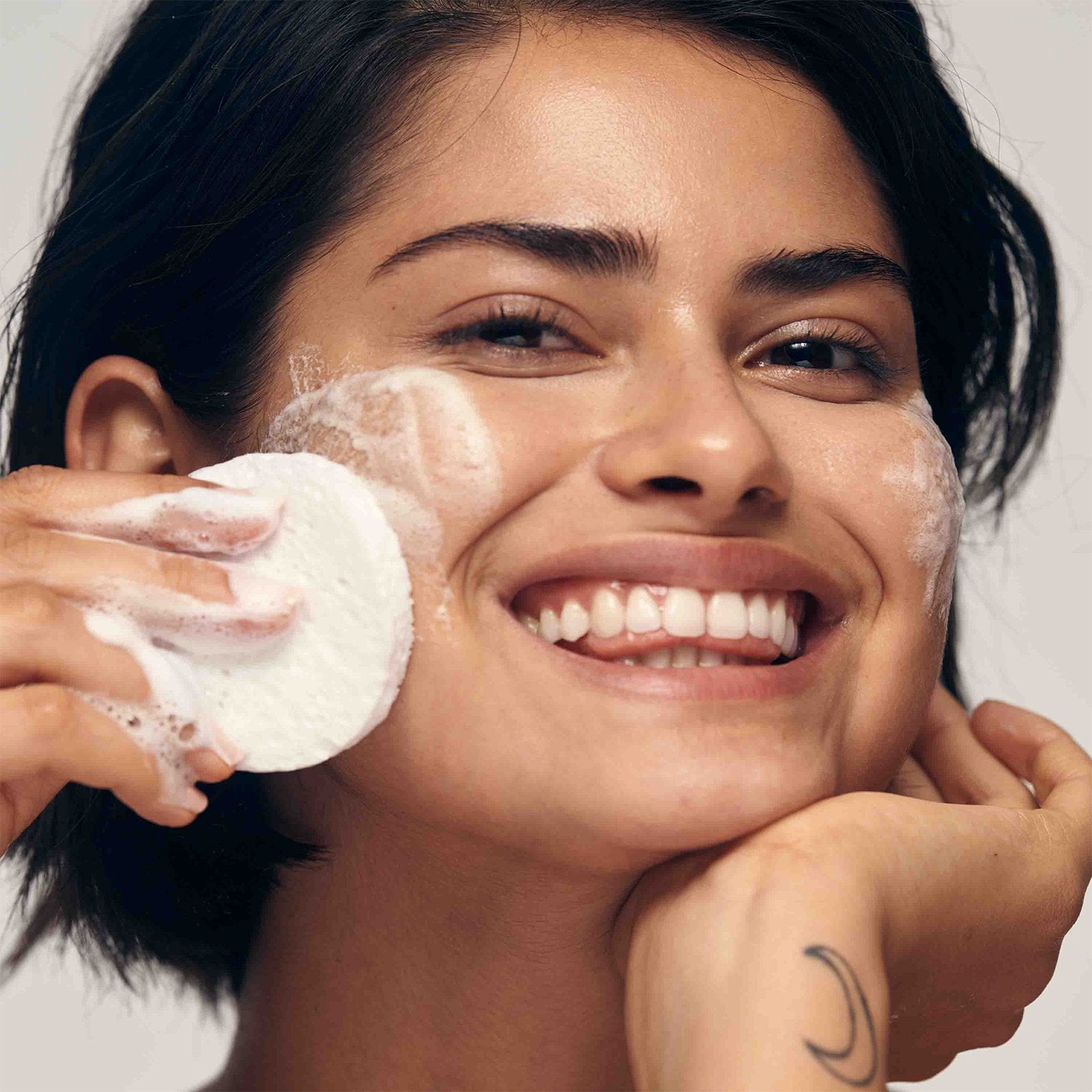 Diverse model lathering her face with the clear skin cleansing bar which is best suited for oily skin types