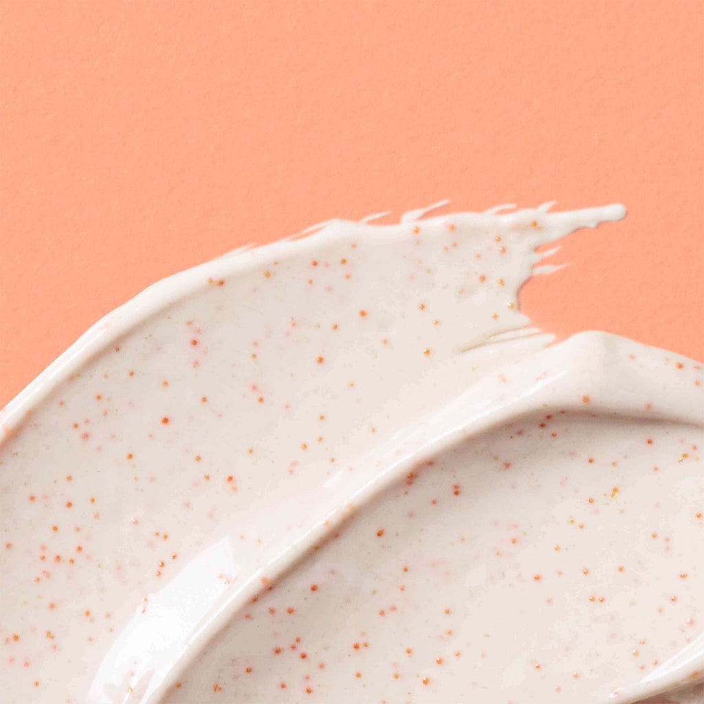 Thick off white swatch of Pumpkin Pore Detox Mask & Scrub containing small orange jojoba beads 